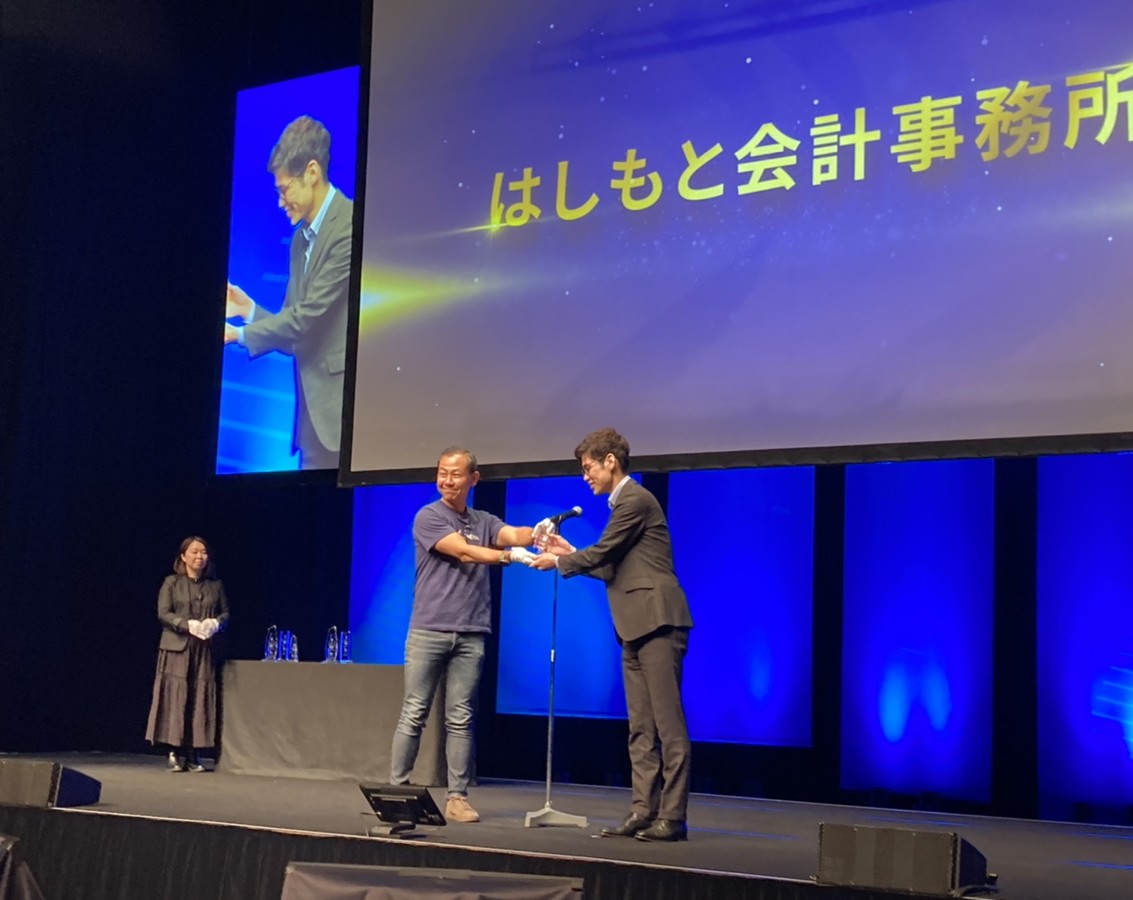 freee Advisor Day 2022 授賞式で佐々木CEOからトロフィーを受け取る様子